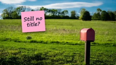 A red mailbox on a post in a green field under a blue sky, with a sticky note reading “Still no title?”.