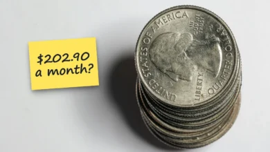 A stack of U.S. quarters on a white surface, with a sticky note reading “$202.90 a month?”.