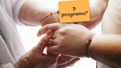 An older woman's hands holding a younger woman's hand against a bright white background, with a sticky note reading “3 programs?”.